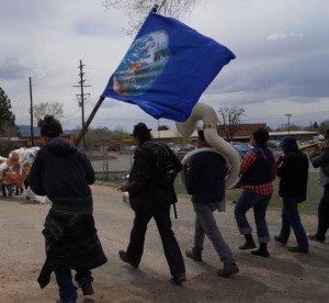 Brave New Burro (the brass band) and a windblown Earth Flag carrier during the Global Climate Convergence Community Parade in Taos, NM.